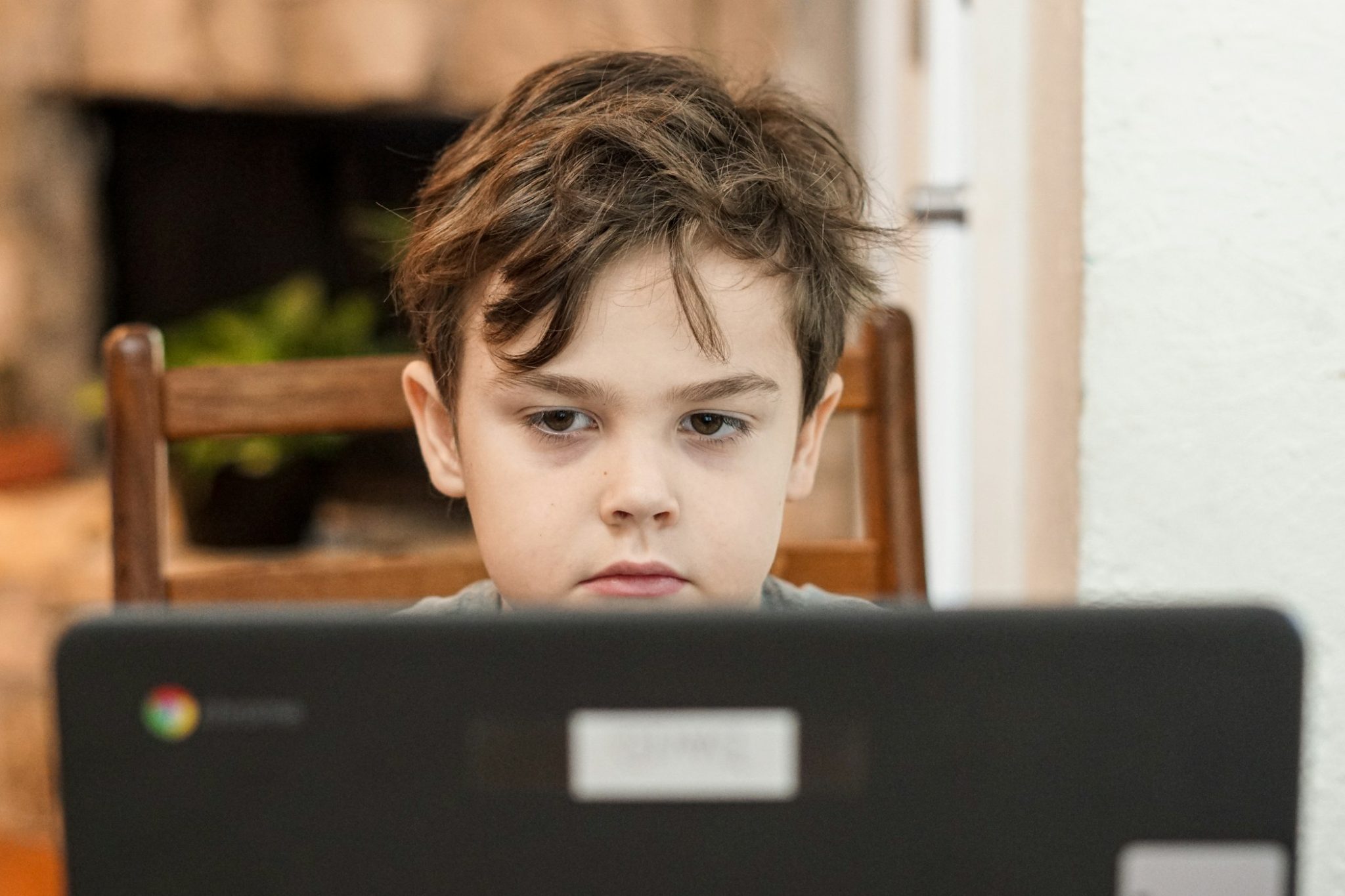 boy in black crew neck shirt online in front of laptop